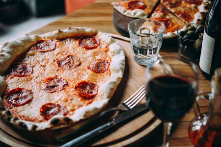 Delicious pizza pepperoni served on a wooden table for dinner.の写真素材