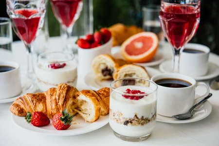 Healthy breakfast served with black coffee, croissant, muesli and fruitsの写真素材