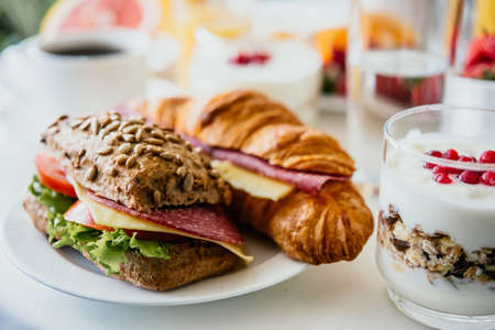 Healthy breakfast served with coffee, frouts and sandwiches and muesliの写真素材