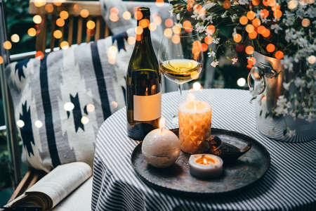 Wine bottle, glass and candles on a beautiful terrace or balconyの写真素材