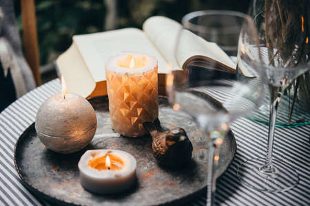 Candles, wine glass and book on a tableの写真素材