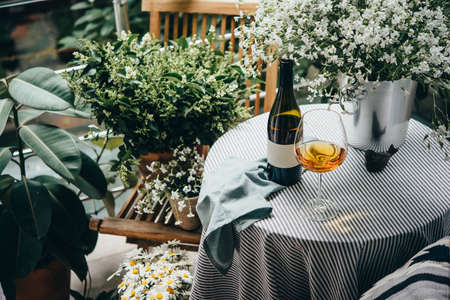 Wine bottle, glass and flowers on a beautiful terrace or balconyの写真素材