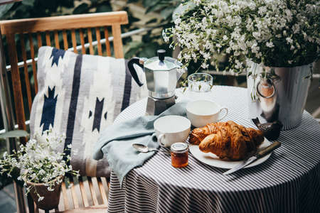 Breakfast with croissants and coffee served on a beautiful terrace or balconyの写真素材
