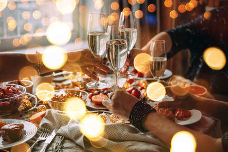 Party table with glasses of champagne. Friends celebrating Christmas or New Year eve.の写真素材