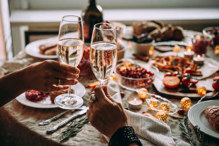 Party table with glasses of champagne. Friends celebrating Christmas or New Year eve.の写真素材
