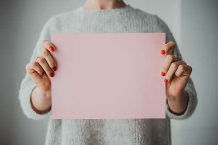 Young woman holding piece of paperの写真素材