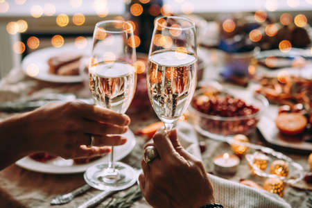 Party table with glasses of champagne. Friends celebrating Christmas or New Year eve.の写真素材