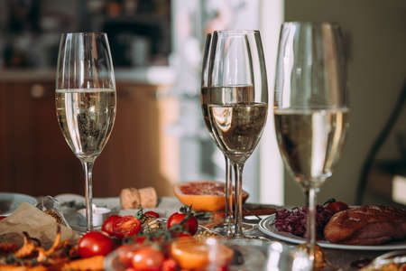 Party table with glasses of champagne. Friends celebrating Christmas or New Year eve.の写真素材