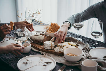 Enjoying cheese and wine at a dinner or celebration party with friends.の写真素材