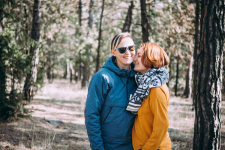 Happy lesbian couple walking in the forestの写真素材