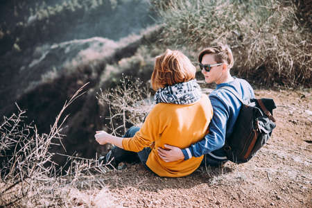 Happy lesbian couple sitting on a hillの写真素材