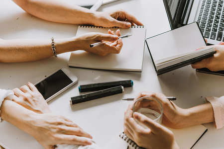 Laptops, mobile phones and notebooks on a working table in creative office. Successful teamwork and...