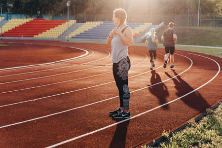 A young beautiful woman is getting ready for jogging of exercising at a stadium running track.の写真素材