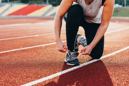 A young beautiful woman is getting ready for jogging of exercising at a stadium running track.