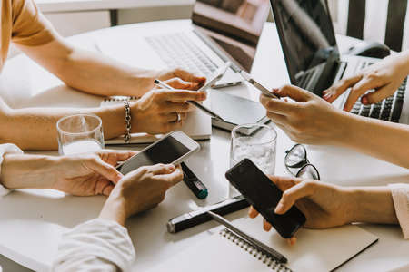 Laptops, mobile phones and notebooks on a working table in creative office. Successful teamwork and business startup concept.の写真素材