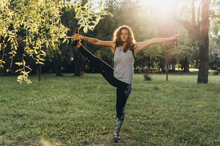 A young beautiful woman is meditating or practising yoga outdoors. Outdoor recreation concept.の写真素材