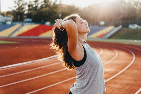 A young beautiful woman is getting ready for jogging of exercising at a stadium running track.の写真素材