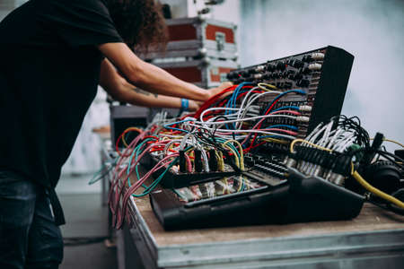 Musician performs on stage using modular synthesizers. Electronic music and professional music equipment concept.の写真素材