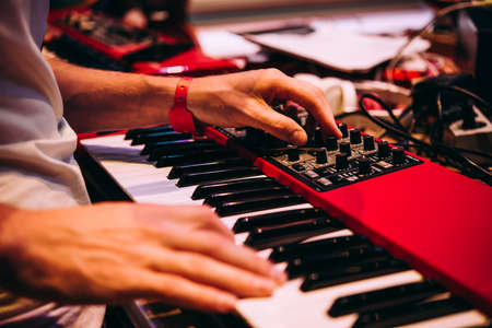Playing music using an analog synthesizer connected to a modular synthesizer. Electronic music and professional music equipment concept.の写真素材