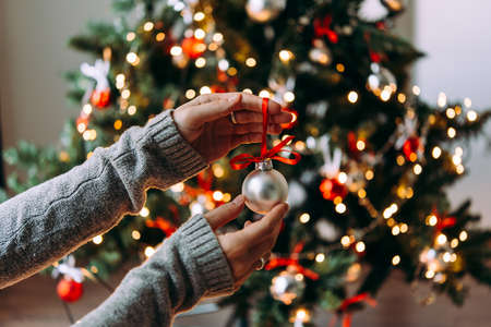 Hands holding a christmas tree decoration glass ball. Christmas and New Year celebration concept.の写真素材