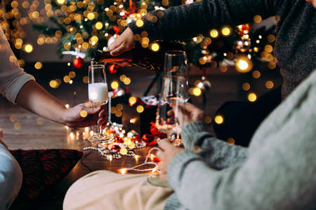 New year and Christmas celebration with champagne in front the Christmas tree.の写真素材