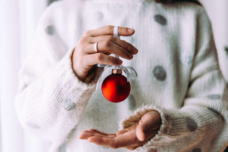 Hands holding a christmas tree decoration glass ball. Christmas and New Year celebration concept.の写真素材