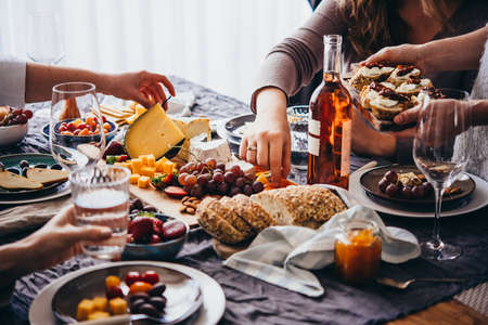 Offering appetizers at a friendly party. Dinner or aperitivo party concept.の写真素材
