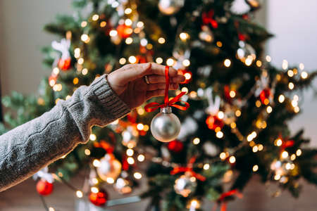 Hands holding a christmas tree decoration glass ball. Christmas and New Year celebration concept.の写真素材