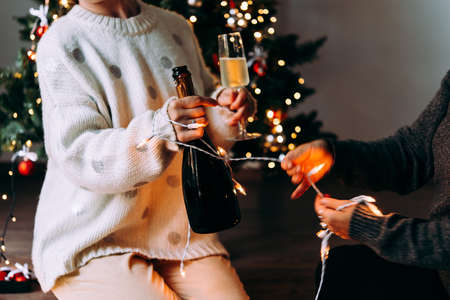 New year and Christmas celebration with champagne in front the Christmas tree.の写真素材