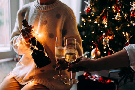 New year and Christmas celebration with champagne in front the Christmas tree.の写真素材