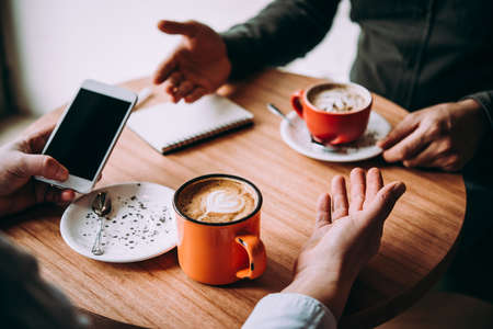 Two persons discussing business projects in a cafe while having coffee. Startup, ideas and brain storm conceptの写真素材