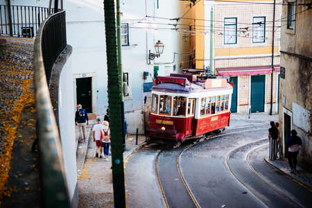 A view of old tram passing by in one of the streets of Lisbon, Portugal.の写真素材