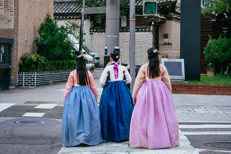 Ladies wearing traditional koran dresses walk along the streets of Seoul, South Korea.のeditorial素材