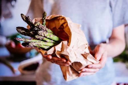 Hands holding a pack of asparagus. Healthy eating concept.の写真素材