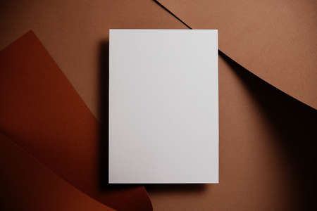 Stylish white blank paper mockup on a colorful background. Document and presentation stationery creator. Selective focus on paperの写真素材