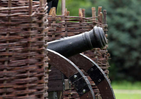 Old cannon standing between wicker ramparts