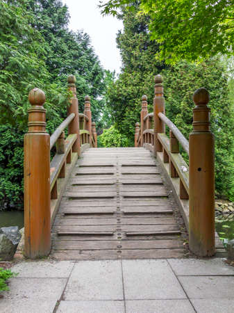 entrance to japanese red bridge - taiko bashi, characteristic element of japanese gardensの写真素材