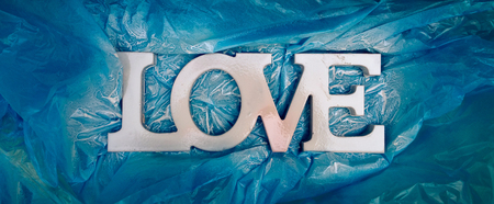 LOVE typography - Just painted white sign in honor of Valentine's Day on a blue backgroundの写真素材