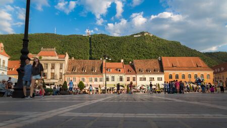 Buildings and people in the main square and mountain with sign of Brasov, Romania 20.08.2017のeditorial素材