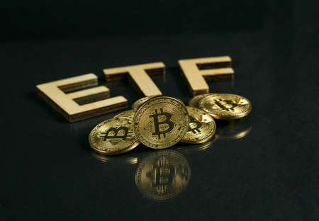 Bitcoin coin with ETF text Put on wooden floor, Concept Entering the Digital Money Fund.の写真素材