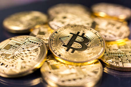 Stack of bitcoins lying on shiny dark surfaceの写真素材