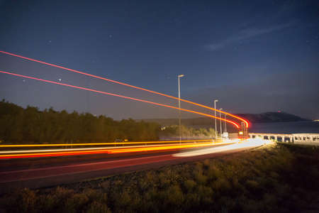 Truck light trails in tunnel. Art image . Long exposure photo taken on a road next to seasideの写真素材