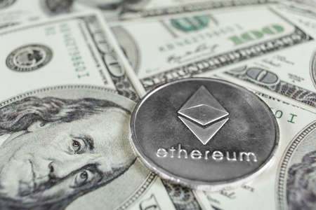Silver Ethereum on hundred dollars bills. Close-up, macro shot.の写真素材