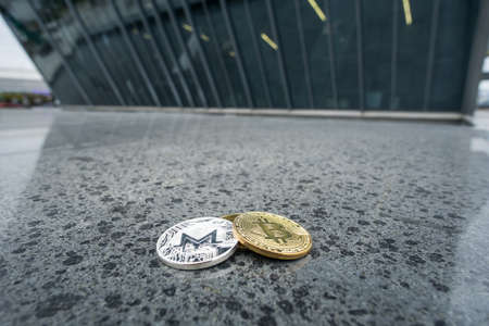 Bitcoin and Monero coin, infront of business architectureの写真素材