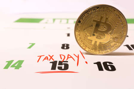 Bitcoin and 2019 calendar with 1040 income tax form for 2018 showing tax day for filing on April 15の写真素材