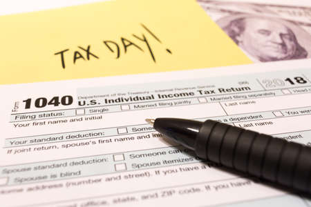 1040 income tax form with pen for 2018 showing tax day for filing on April 15の写真素材