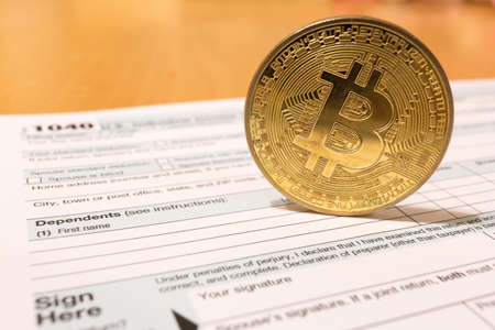 Bitcoin coin with 1040 income tax form for 2018 for filing on April 15の写真素材