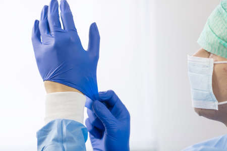 Surgeon doctor in sterile gloves preparing for operation in hospital. He is wearing surgical cap and...