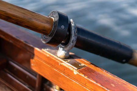 Closeup photo of wooden paddle attached to boat used for rowing in the water, lake Bled on a sunny dayの写真素材