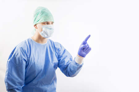 Surgeon doctor in sterile gloves preparing for operation in hospital. He is wearing surgical cap and blue gownの写真素材